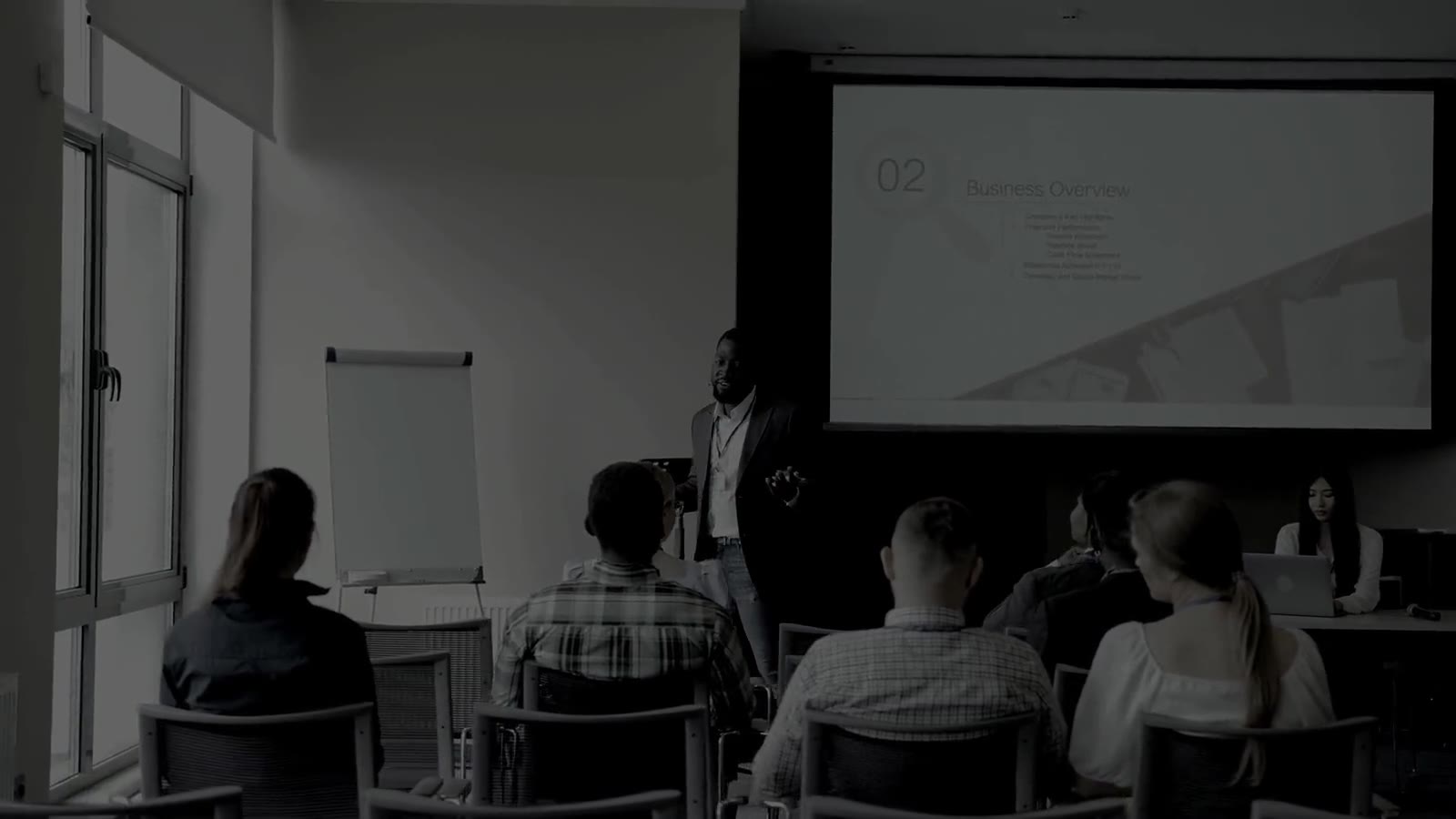 A presenter speaking to a seated group